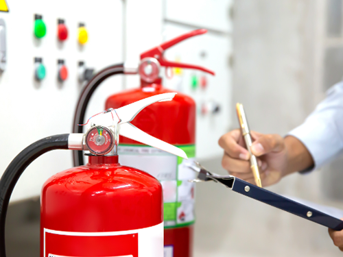 Responsible person completing a fire safety checklist in their workplace.