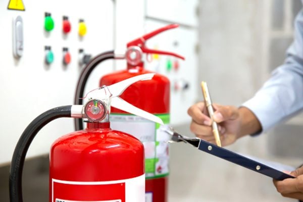 Employee completing the fire safety checklist at work.