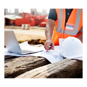 Site Supervisor with white hard hat looking over plans on site.