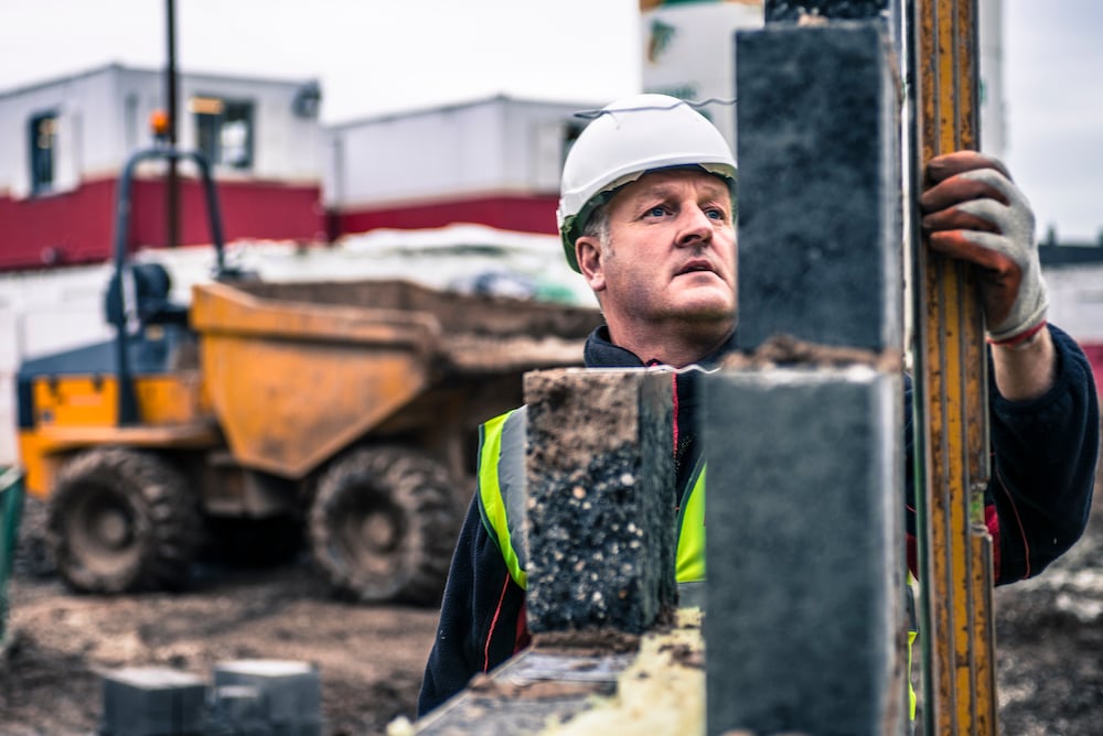 Workers laying bricks on construction site