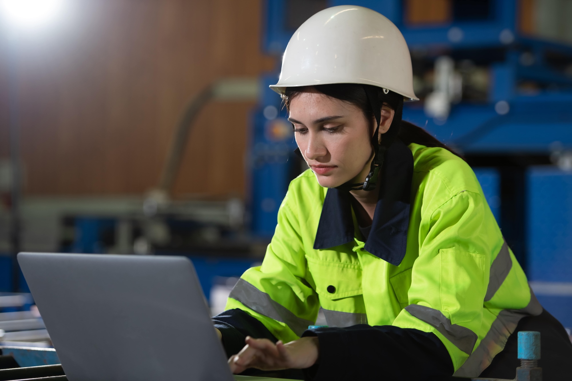 woman-wearing-hard-hat-and-hi-vis-jacket-taking-smsts-course-on-laptop