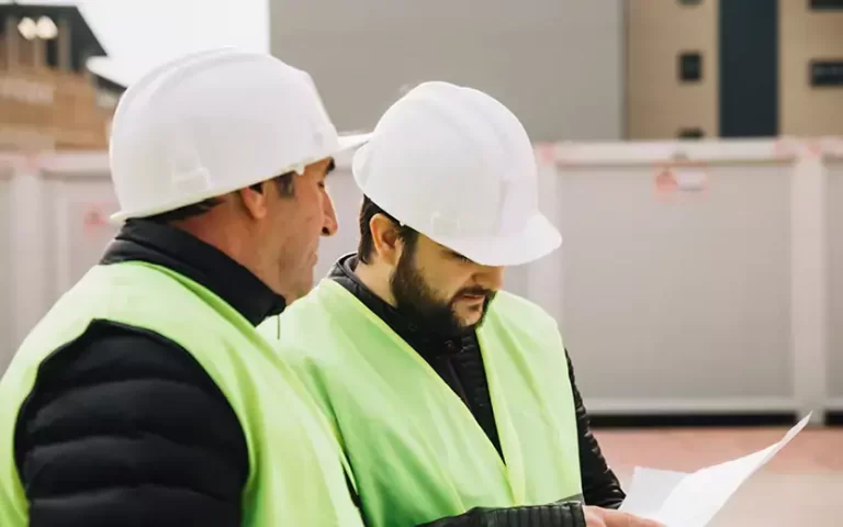 Two men looking over plans to build safely