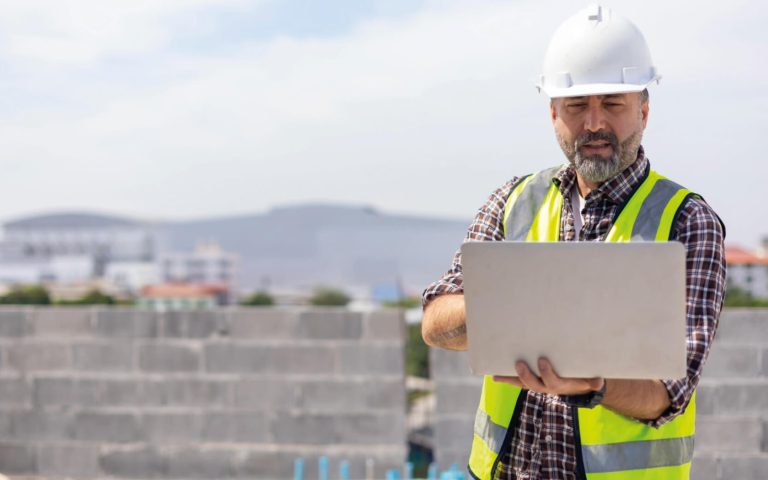 Construction worker on laptop complying with Building Safety Regulations