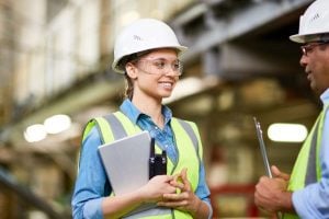 Construction woman smiles holding clipboard