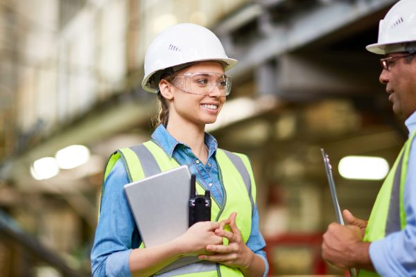 Construction woman smiles holding clipboard