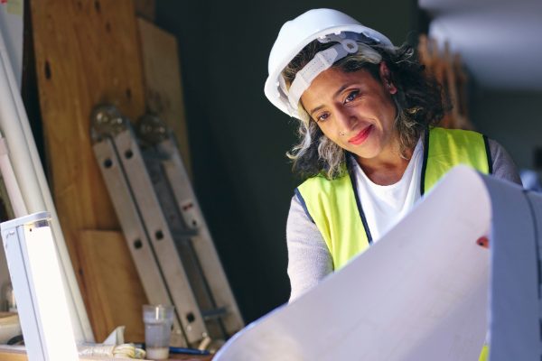 Construction woman looks at blueprints