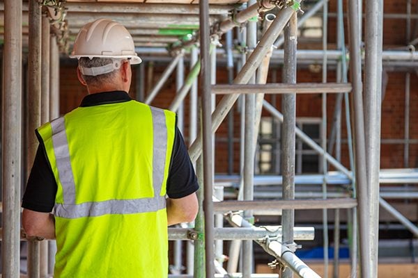 Man works on scaffolding along side of building
