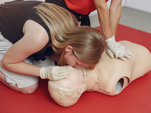 Woman performing CPR after a first aid course.