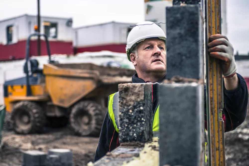 Workers laying bricks on construction site