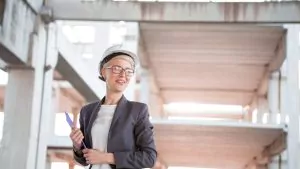 Woman in hard hat holds clipboard