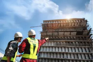 Two builders survey a building