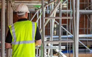 Man works on scaffolding along side of building