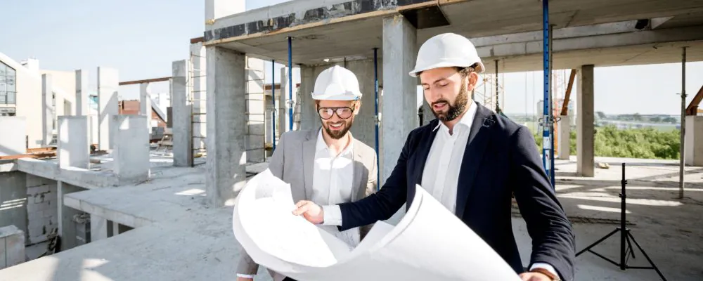 Two men review construction plans