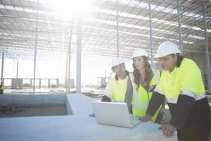 what is a level 4 nvq - 3 construction workers looking at laptop screen
